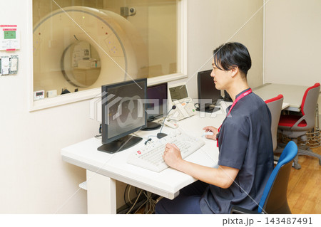 CT検査の画像をチェックする日本人男性検査技師 143487491