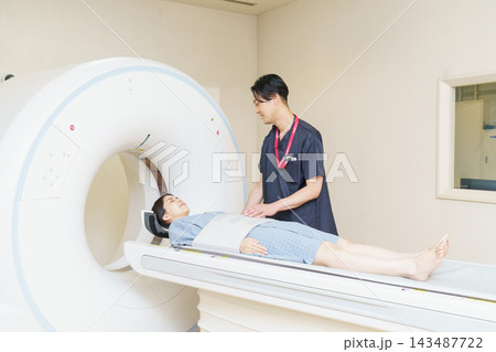 CTスキャンを受ける若い日本人女性と男性放射線技師 CTスキャンを受ける若い日本人女性と男性放射線技師 143487722