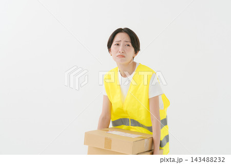 段ボールを持つ疲れた表情の配達員 段ボールを持つ疲れた表情の配達員 143488232