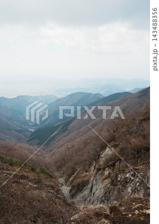 霞んだ深い谷と奥へ重なる山の斜面 143488356