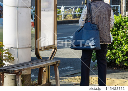 バス停でバスを待つ買い物帰りのシニア女性 バス停でバスを待つ買い物帰りのシニア女性 143488531