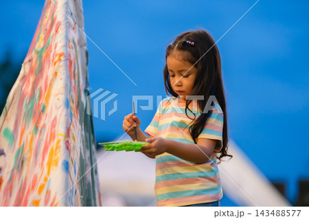 preschool child girl painting watercolors on canvas outdoors in park preschool child girl painting watercolors on canvas outdoors in park 143488577