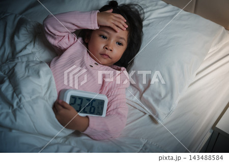 tired preschool child girl having trouble sleeping and headache in bed late at night, insomnia concept tired preschool child girl having trouble sleeping and headache in bed late at night, insomnia concept 143488584
