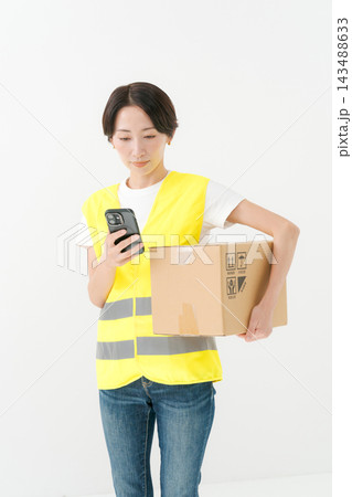 段ボールを持つ配達員の女性 143488633
