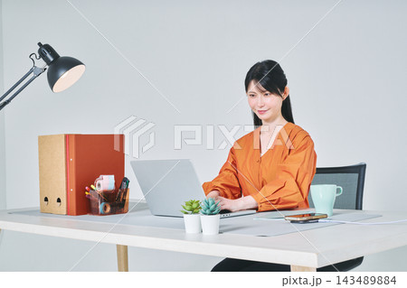 デスクで仕事をする女性 デスクで仕事をする女性 143489884