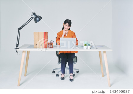デスクで仕事をする女性 デスクで仕事をする女性 143490087