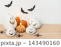 Decorating for halloween with ceramic pumpkins and lit candles 143490160