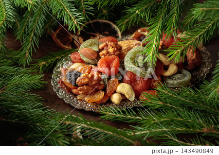 Assorted dried fruits and nuts on a silver tray. 143490849