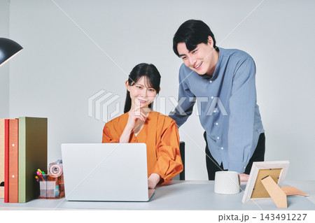 デスクで仕事をする男女 デスクで仕事をする男女 143491227