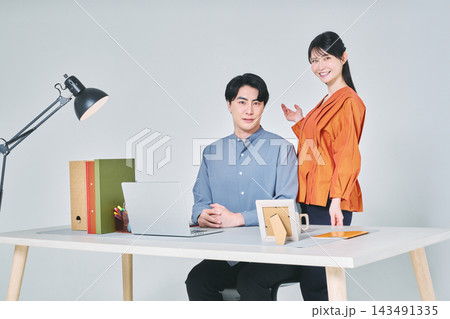 デスクで仕事をする男女 デスクで仕事をする男女 143491335