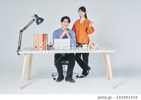 デスクで仕事をする男女 143491434