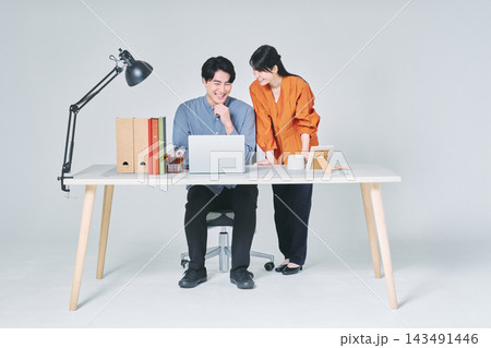 デスクで仕事をする男女 143491446