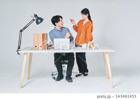 デスクで仕事をする男女 143491455