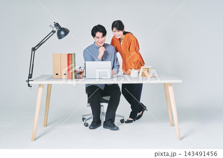 デスクで仕事をする男女 143491456