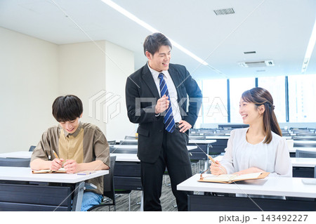 セミナーで男性講師から指導を受ける若手ビジネスパーソン 143492227