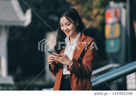 Young businesswoman smiling while working with digital tablet at modern office building 143493206