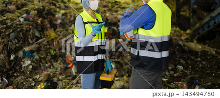 Industrial engineers in safety gear inspect recycling machinery and organic waste sorting processes at modern green energy factory facility. Industrial engineers in safety gear inspect recycling machinery and organic waste sorting processes at modern green energy factory facility. 143494780