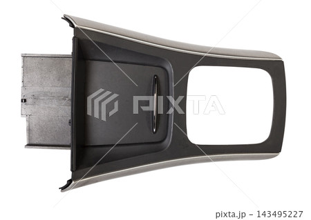 Dismantled car center console on a white isolated background in a photo studio - gray plastic panel with metal elements, spare part for sale and installation in a auto service center. Dismantled car center console on a white isolated background in a photo studio - gray plastic panel with metal elements, spare part for sale and installation in a auto service center. 143495227