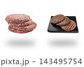 Stacked raw burger patties beside grilled meat cutlets on a black plate floating above soft shadows on white 143495754