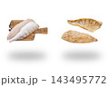 Raw zander fillets on wooden boards beside golden cooked fish portions floating above soft shadows on white 143495772