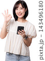 Happy smiling asian woman holding smartphone making ok hand sign showcasing modern artificial intelligence digital mobile communication technology isolated on transparency background 143496180