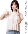 Happy smiling young asian woman holding smartphone talking with artificial intelligence assistant feature showing thumb up gesture isolated on transparency background 143496182