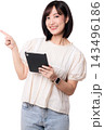 Happy smiling young asian woman holding tablet pointing finger up showing artificial intelligence concept isolated on white studio background with copy space 143496186