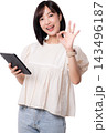 Happy asian woman holding tablet device showing okay gesture with cheerful smile and positive energy for modern artificial intelligence tech concept isolated on transparency background 143496187