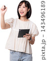 Happy asian woman writes artificial intelligence software on virtual screen holding digital tablet studio background pointing marker showing excited joyful expression during presentation 143496189
