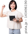 Happy smiling young asian woman holding tablet computer writing invisible screen isolated transparency background depicting modern technology, artificial intelligence and future work 143496190