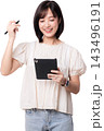 Happy asian woman holding digital tablet using artificial intelligence stylus pen for modern creative design work isolated against transparency background studio setup 143496191