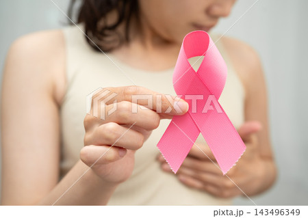 Asian woman with pink ribbon for October world breast cancer day. Asian woman with pink ribbon for October world breast cancer day. 143496349