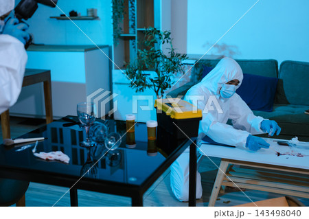 Forensic expert collecting a blood sample at a crime scene for laboratory analysis, DNA testing, criminal investigation, evidence examination, and justice. Forensic expert collecting a blood sample at a crime scene for laboratory analysis, DNA testing, criminal investigation, evidence examination, and justice. 143498040