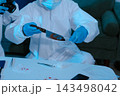 Forensic expert collecting a blood sample at a crime scene for laboratory analysis, DNA testing, criminal investigation, evidence examination, and justice. 143498042