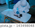 Forensic expert collecting a blood sample at a crime scene for laboratory analysis, DNA testing, criminal investigation, evidence examination, and justice. 143498048