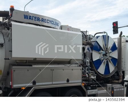 A modern sewer cleaning truck with water recycling equipment stands at a city intersection during the day, highlighting advanced waste management and urban municipal infrastructure 143502394