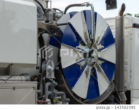 A large blue and white industrial hose reel on a utility truck for sewer cleaning operations, showing heavy duty plumbing maintenance equipment for municipal urban infrastructure repair A large blue and white industrial hose reel on a utility truck for sewer cleaning operations, showing heavy duty plumbing maintenance equipment for municipal urban infrastructure repair 143502395