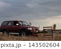 Vehicle parked near a table and chairs in an field. 143502604