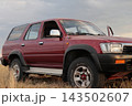 Red Toyota truck parked in a field. 143502607