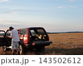 Man takes photographs in a field during sunset. 143502612