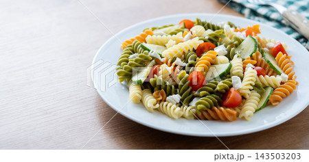 Colorful fusilli pasta salad with fresh vegetables and feta cheese Colorful fusilli pasta salad with fresh vegetables and feta cheese 143503203