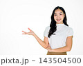 Young Asian Woman Smiling and Pointing to Copy Space on White Background Young Asian Woman Smiling and Pointing to Copy Space on White Background 143504500