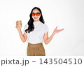 Asian Girl with Sunglasses Holding Coffee Cup Presenting on White Background Asian Girl with Sunglasses Holding Coffee Cup Presenting on White Background 143504510