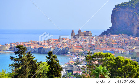 Cefalu, Italy. 22 August 2026. A panoramic view of the old town, situated right by the sea and featuring beautiful architecture. The La Rocca rock towers over the town. Cefalu, Italy. 22 August 2026. A panoramic view of the old town, situated right by the sea and featuring beautiful architecture. The La Rocca rock towers over the town. 143504950
