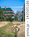 Masaryk's cottage stands on Serlich in the Orlicke Mountains. The path leads up to the cottage surrounded by grass and trees. Clear blue skies can be seen above. 143505186