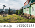 Masaryk's cottage stands in the Orlicke Mountains. Visitors can enjoy the beautiful scenery and nearby trail signs. The cottage features a green and red exterior. 143505188