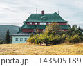 Masaryk's cottage on Serlich stands in the Orlicke Mountains. It is a well-known spot, surrounded by trees and grassy fields. Visitors often enjoy activities nearby in nature. 143505189