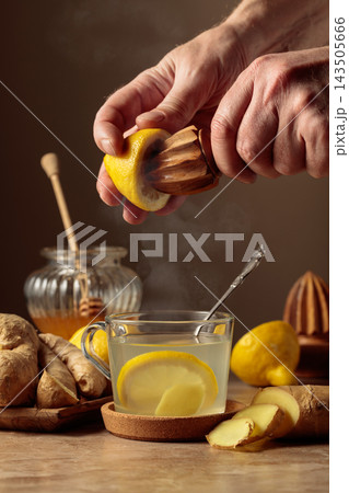 Ginger tea with lemon and honey on a brown ceramic table. Ginger tea with lemon and honey on a brown ceramic table. 143505666
