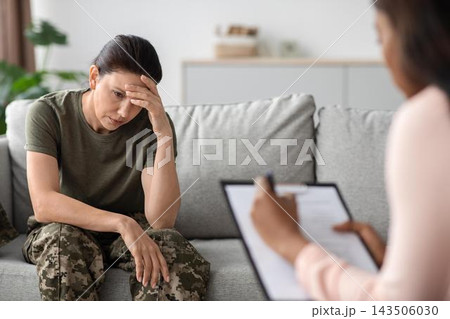 Worried Latina Woman Sitting On Couch Speaking With Female Therapist In Office, Seeking Help And Support For Mental Health Issues, Engaging In Counseling Session In Professional Setting. Worried Latina Woman Sitting On Couch Speaking With Female Therapist In Office, Seeking Help And Support For Mental Health Issues, Engaging In Counseling Session In Professional Setting. 143506030