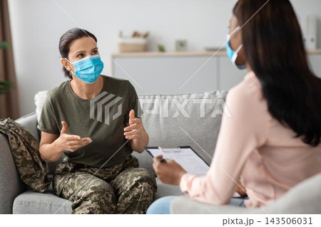 Worried Female Soldier Of Caucasian Ethnicity Discussing Mental Health Issues With Therapist In An Office Setting, Engaging In A Supportive Conversation To Address Emotional Wellbeing And Care. Worried Female Soldier Of Caucasian Ethnicity Discussing Mental Health Issues With Therapist In An Office Setting, Engaging In A Supportive Conversation To Address Emotional Wellbeing And Care. 143506031